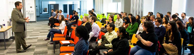 A lecturer speaking to a class of students